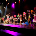 Kinderzirkus - Kinder tanzen auf Bühne mit Lufballons