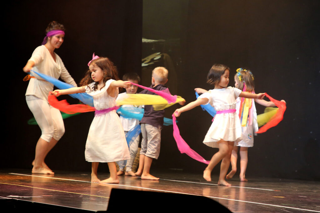Kinder tanzen mit Bänder