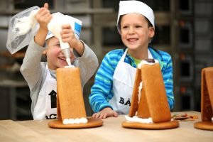Kinder backen Lebkuchenhäuser